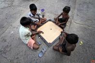 Slum children playing carrom.