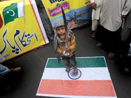 Pakistan boy standing on Indian flag.