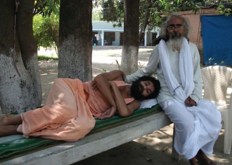 Swami Nigamananda rests in the lap of his guru Swami Shivananda . 