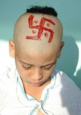 Hindu boy with a swastika drawn on his head during a upanayana ceremony.