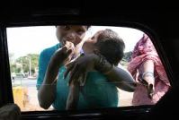 Begging from cars at a Mumbai intersection.