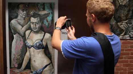 A visitor takes a picture of the artwork entitled "Travesty" by Altunin at an exhibition at the Muzei Vlasti in St. Petersburg.