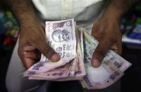 A private money trader counts Indian Rupee currency notes at a shop in Mumbai.