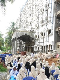 Students seated in front of the new university building.