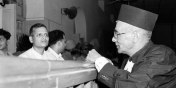 Nathuram Godse, left, one of nine co-defendants in the Mohandas Gandhi assassination conspiracy case, and defense counsellor L.B. Bhopatkar confer May 27, 1948, at the start of the court hearing. (AP Photo)