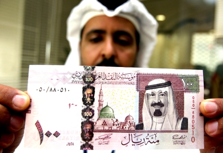 Saudi banker displays the new one hundred riyal note