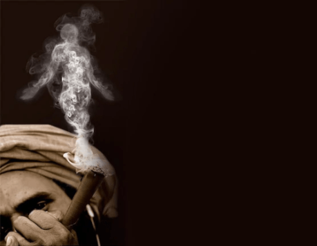 Villager smoking ganja in a chillum.