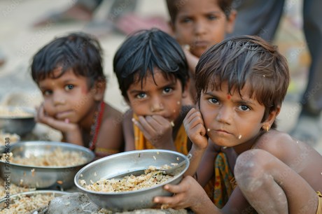 Pradhan Mantri Garib Kalyan Anna Yojana provides free food grains to about 81.35 crore beneficiaries. Street children eating rice.