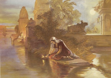 Woman offering lamp to the Ganga.