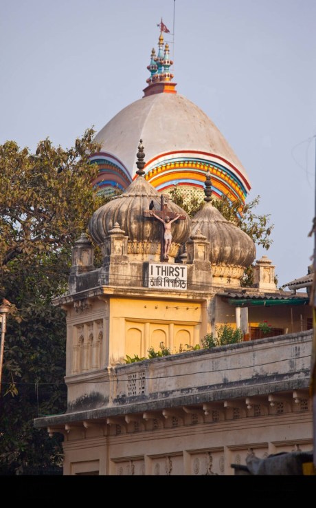 Kalighat Temple with Nirmal Hriday in front. Note the crucifix and slo9gan "I Thirst" placed on the Nirmal Hriday roof.